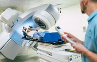 A patient laying beneath a radiotherapy machine